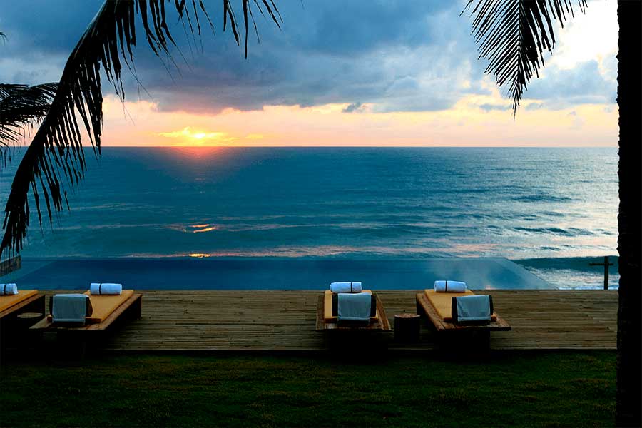 Золотой закат в Kenoa Exclusive Beach Spa & Resort, океан и пальмы на фоне неба