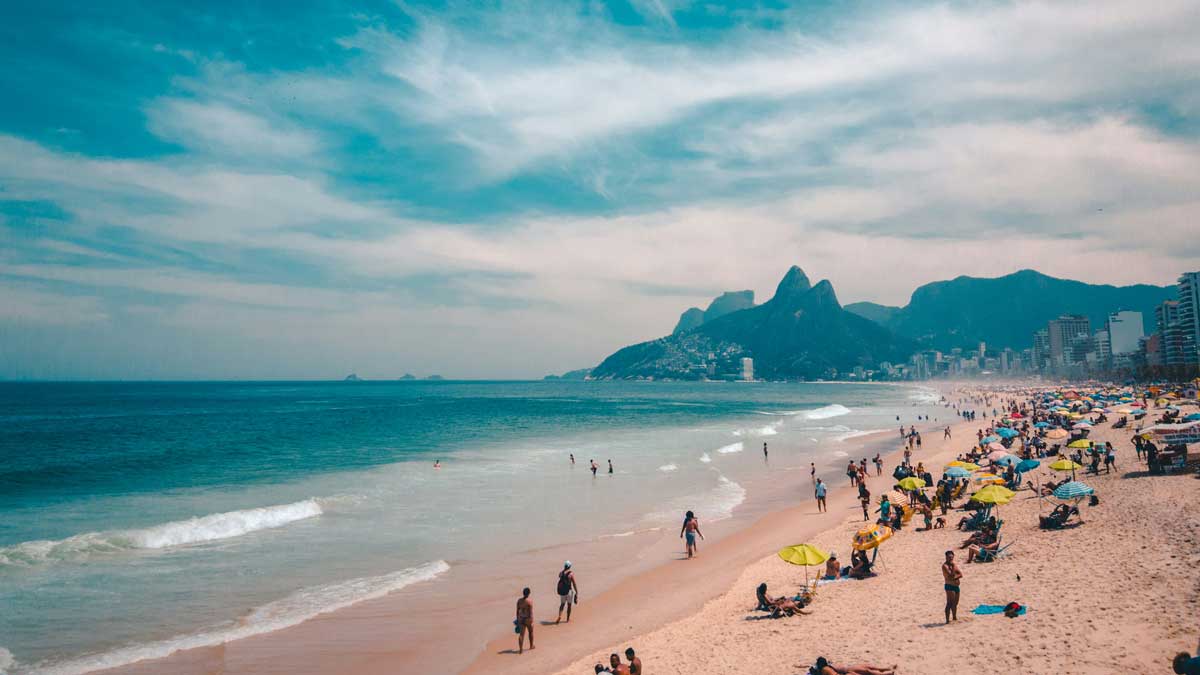 Знаменитый пляж Копакабана в Рио-де-Жанейро, черно-белая мозаика на набережной, вид на океан и холмы